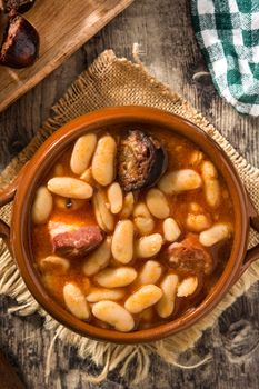 Typical Spanish fabada asturiana in crockpot on wooden table