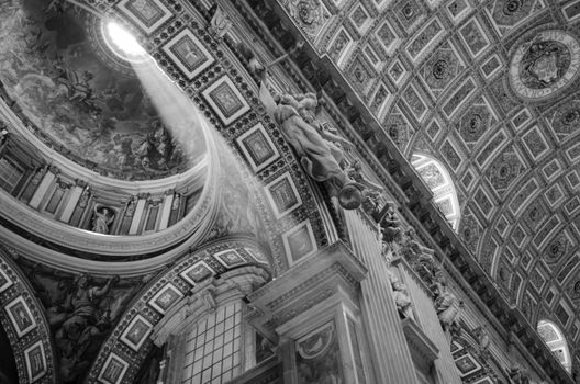 Rays of light inside the basilica of San Pietro. Dome of a chapel and the magnificient ceiling in a black and white picture