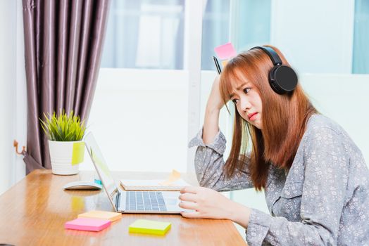 Work from home concept, Happy Asian beautiful young business woman wearing headphone call online conference video call meeting for discussion talking with boos and team together by laptop computer