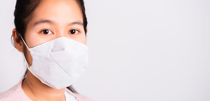 Asian beautiful woman wearing protection face mask against coronavirus her looking to camera, studio shot isolated on white background with copy space, COVID-19 or corona virus concept