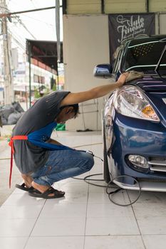 Bangkok, Thailand - January 16, 2016 : Unidentified car care staff cleaning the car (Car detailing).