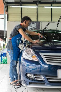 Bangkok, Thailand - January 16, 2016 : Unidentified car care staff cleaning the car (Car detailing).