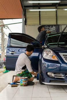 Bangkok, Thailand - January 16, 2016 : Unidentified car care staff cleaning the car (Car detailing).