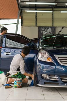 Bangkok, Thailand - January 16, 2016 : Unidentified car care staff cleaning the car (Car detailing).