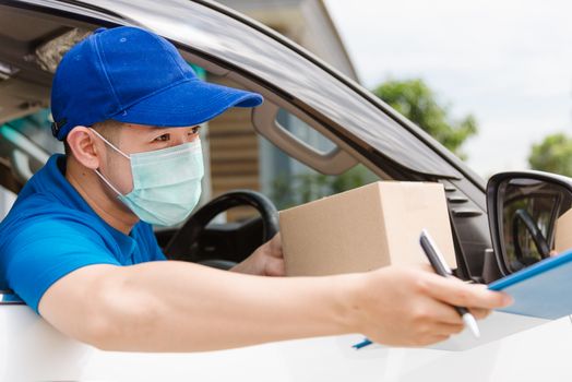 Asian delivery courier young man driver inside van car giving parcel post boxes to customer receiving both protective face mask, under curfew quarantine pandemic coronavirus COVID-19