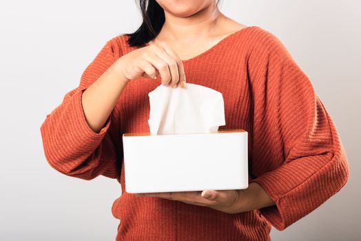 Young woman flu she using hand taking pulling white facial tissue out of from a white box for clean handkerchief, studio shot isolated on white background, Healthcare medicine concept