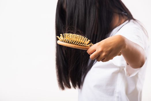 Asian woman unhappy weak hair she shows hairbrush with damaged long loss hair in the comb brush on hand, studio shot isolated on white background, medicine health care concept