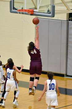 Exciting plays being made by young girls playing basketball