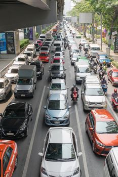 Bangkok, Thailand - March 31, 2016 : Car and Motorcycle wait to go at intersection with traffic light on a road.