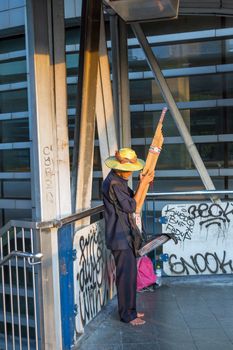 Bangkok, Thailand - May 3, 2016 : Unidentified Thai homeless or beggar playing reed mouth organ on overpass.