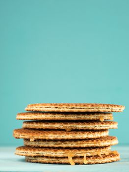 Stroopwafels or caramel Dutch Waffle close up on turquoise wooden background