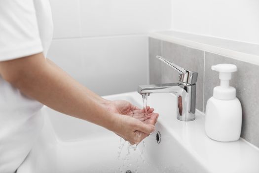 Woman use soap and washing hands under the water tap for corona virus prevention, hygiene to stop spreading coronavirus.