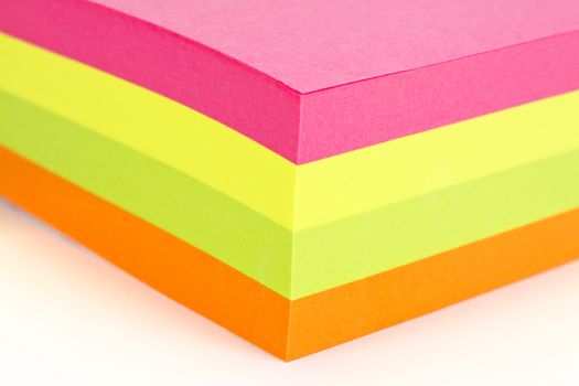 Multi colored sticky note isolated on white background.