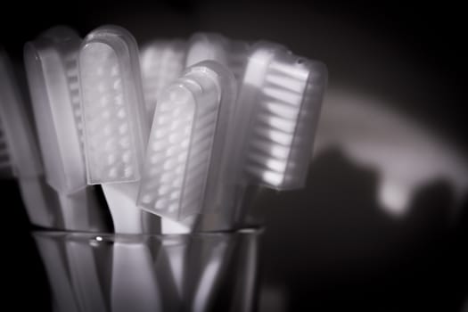 Toothbrushes in a glass. Black background. Todos los derechos reservados. Prohibida su utilización sin autorización. Copyright Gema Ibarra