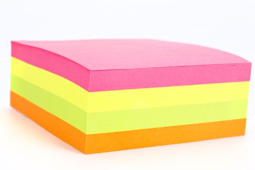 Multi colored sticky note isolated on white background.