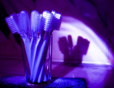 Toothbrushes with bluish purple shadow reflected on the wall. Fotografía de Gema Ibarra. Prohibida su utilización para cualquier uso sin autorización.