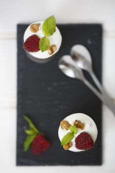 Delicious parfait yogurt dessert with walnuts and raspberries. Top view.
