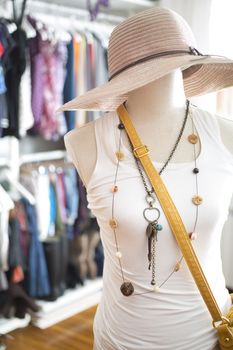 Mannequin with cloths on and closet at background.