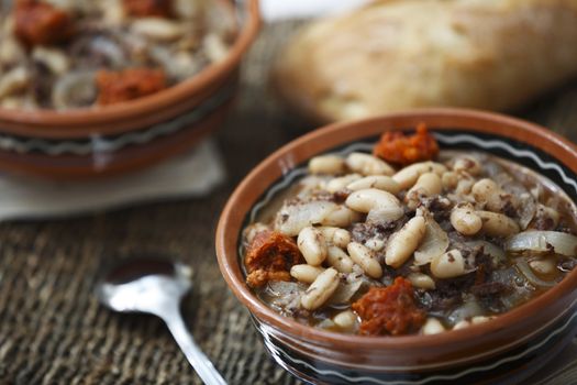 Stew of white beans with spicy sausage and bread.