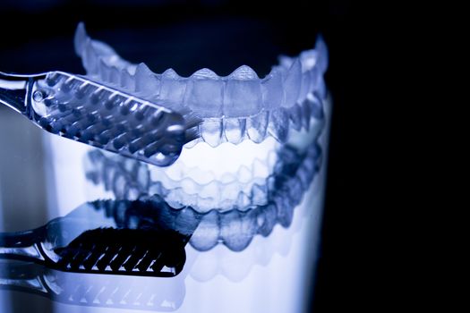 Dental retainers and toothbrush on dark background. Fotografía de Gema Ibarra. Prohibida su utilización para cualquier uso sin autorización.Todos los derechos reservados.