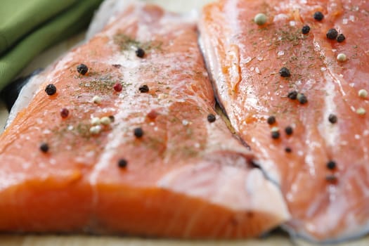 Two raw salmon pieces ready on a chopping board.