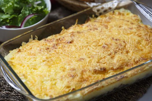 Delicious dish of meat pie with bread and green salad.