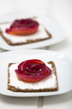 Appetizer of marinated salmon over a black bread with dill dyed with beetroot.