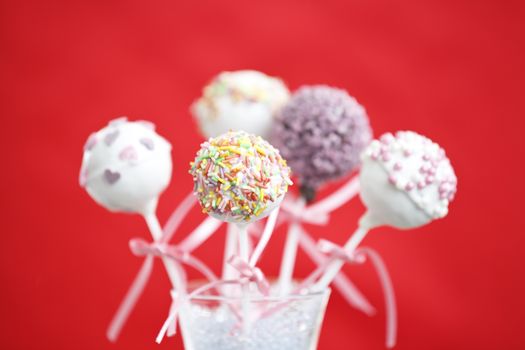 Cakepop over red background.