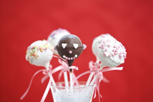 Cakepop over red background.