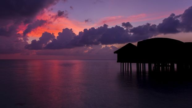 Gorgeous dusk in Maldives. Bungalows are black silhouette.