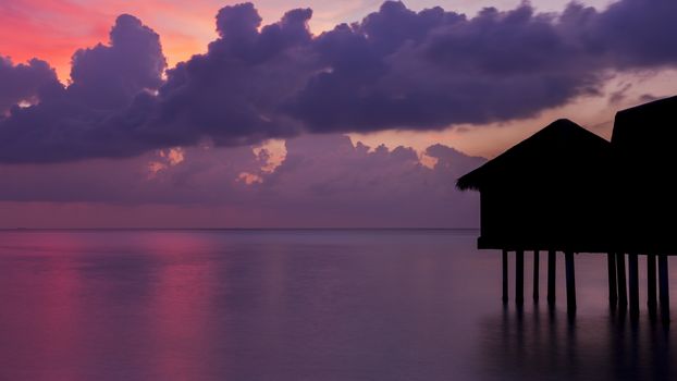 Gorgeous dusk in Maldives. Bungalows are black silhouette.