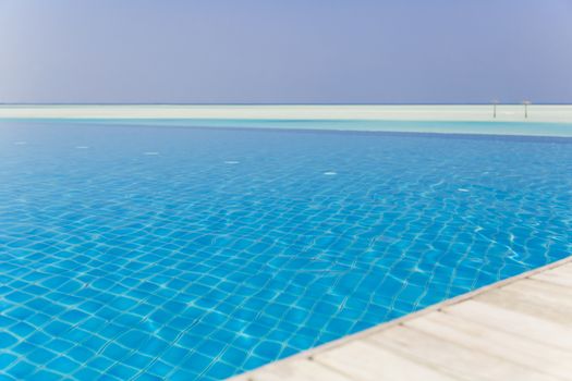 Beautiful shot from edge of a swimming pool with beach at background.
