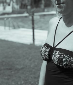 Woman with black bathing suit showing upper body.