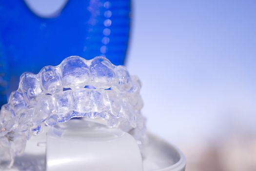 Invisible dental orthodontics in protective case on blue background
