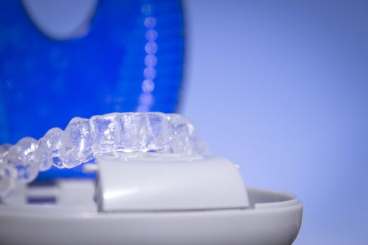 Invisible dental orthodontics in protective case on blue background
