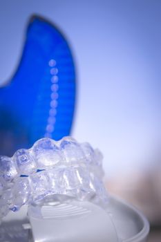 Invisible dental orthodontics in protective case on blue background
