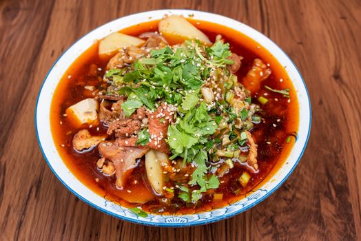 MaoCai sichuan food dish in a bowl on a table with two rice portions