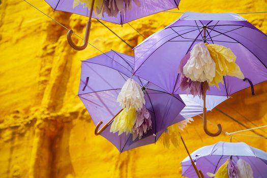 Background of purple umbrellas seen from bottom view in a small city. The very inhabitants were the one creating this art in the street during the Lavender season in a Festival in July. The Festival was held in July the 7th 2019 in a small city called Brihuega, in Guadalajara. SPAIN.