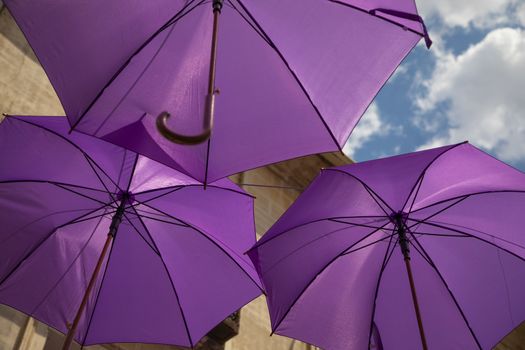 Background of purple umbrellas seen from bottom view in a small city. The very inhabitants were the one creating this art in the street during the Lavender season in a Festival in July. The Festival was held in July the 7th 2019 in a small city called Brihuega, in Guadalajara. SPAIN.