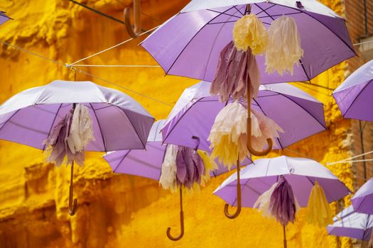 Background of purple umbrellas seen from bottom view in a small city. The very inhabitants were the one creating this art in the street during the Lavender season in a Festival in July. The Festival was held in July the 7th 2019 in a small city called Brihuega, in Guadalajara. SPAIN.