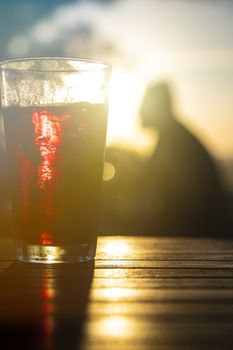 Red wine against the sun with male silhouette at background