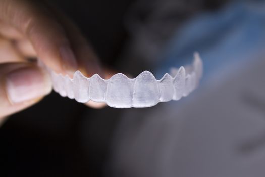 Invisible dental orthodontics held by a womans fingers