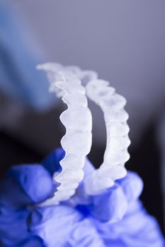 Dentists hand with latex gloves holding a dental orthodontic