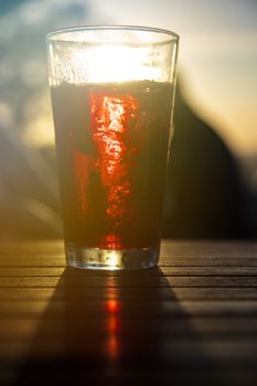 Red wine against the sun with male silhouette at background