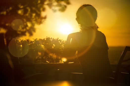 Sunset with the sun against leaving a beautiful silhouette of a woman.