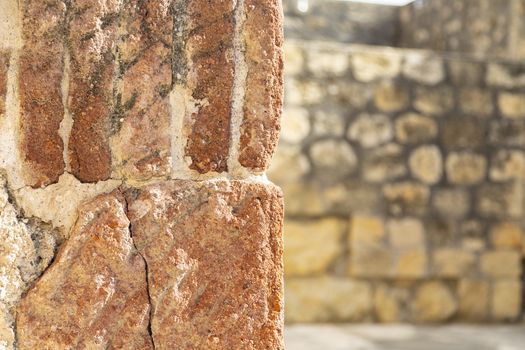 Fragment of wall with wall with stones at background.