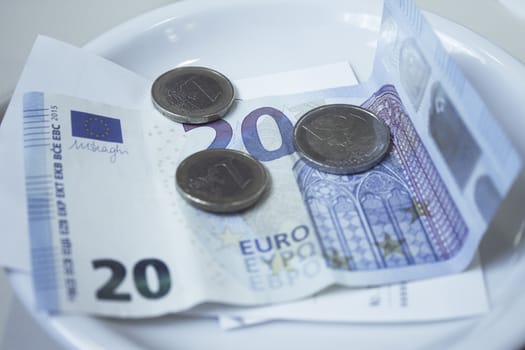 Banknotes and euros on plate