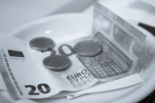 Banknotes and euros on plate