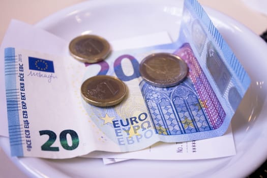 Banknotes and euros on plate