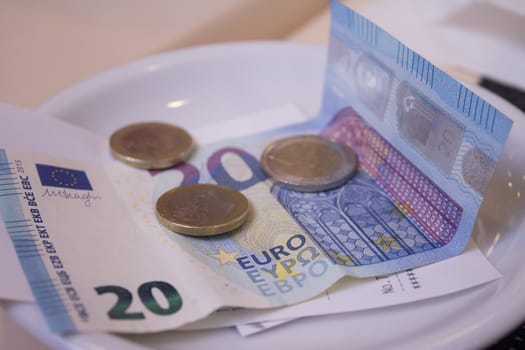 Banknotes and euros on plate